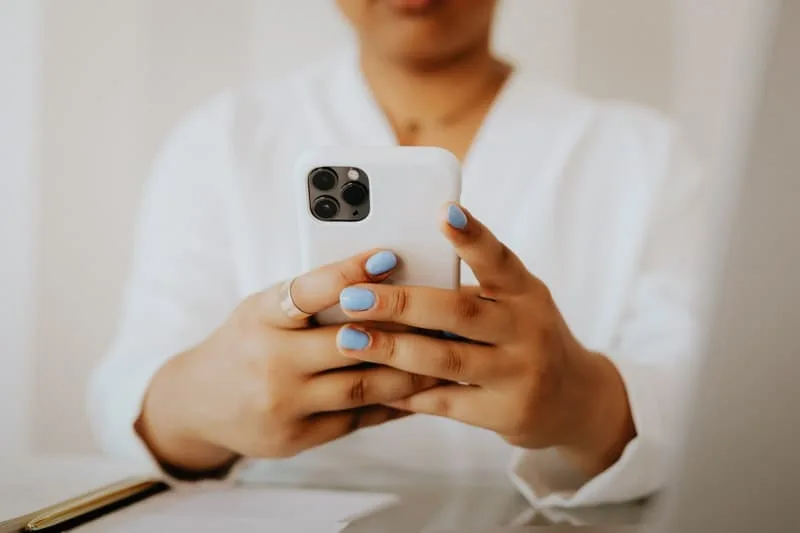 Person med smartphone visar snabb kontakt via SMS för akuta ärenden hos LjuvaHem.